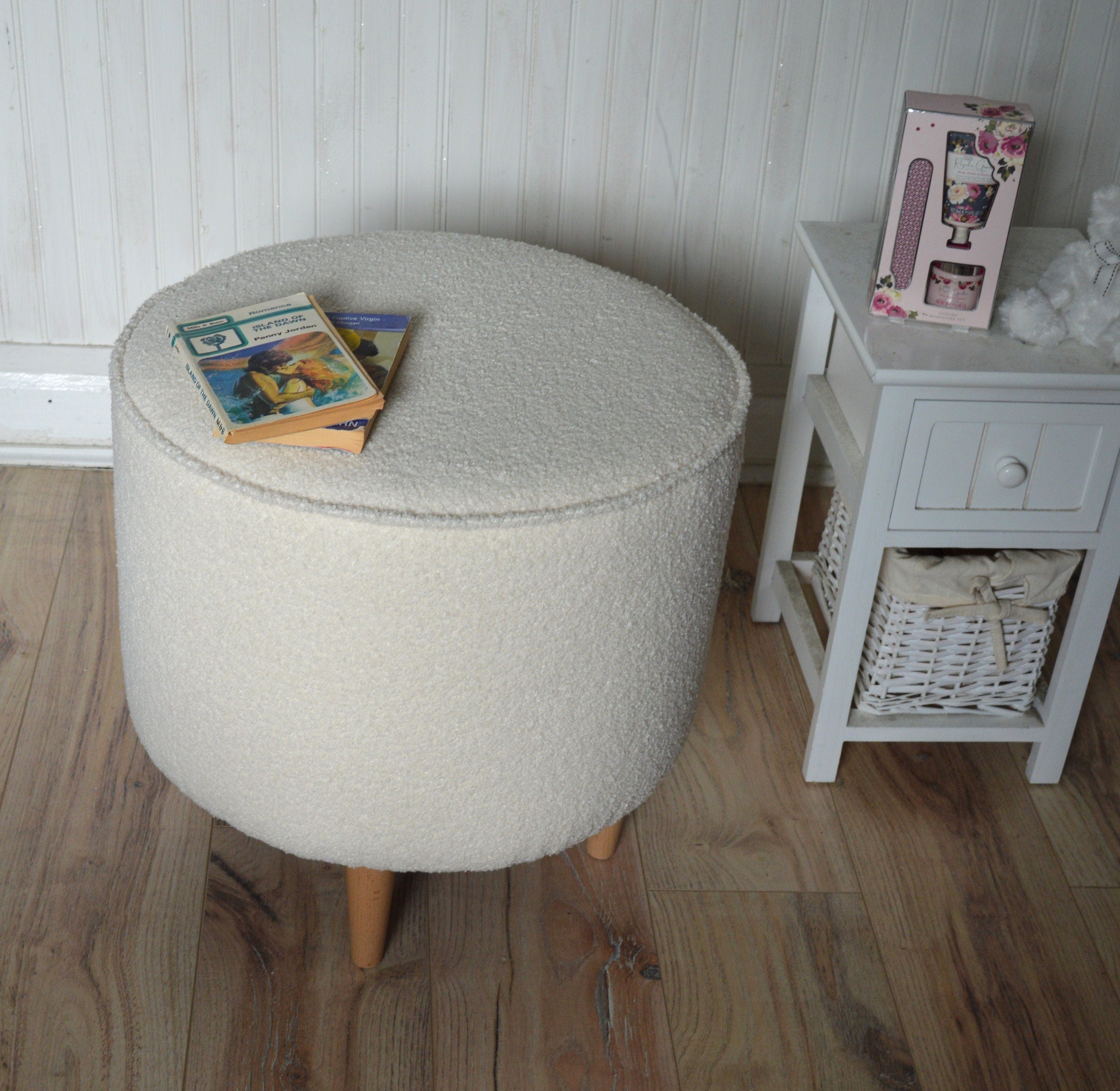 Circular round footstool upholstered in Ivory Boucle Fabric With Natural Hardwood Legs