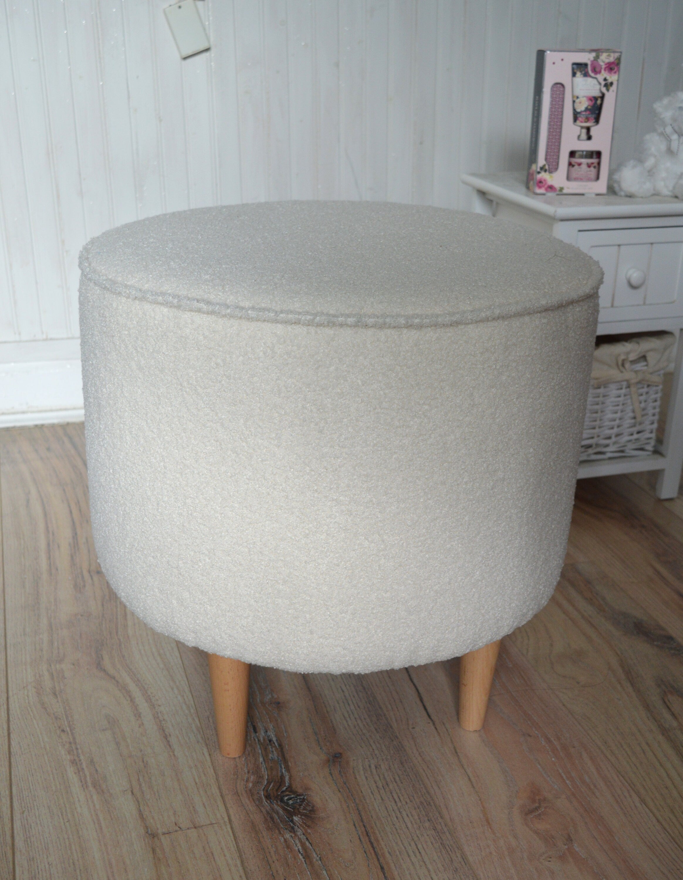 Circular round footstool upholstered in Ivory Boucle Fabric With Natural Hardwood  Legs