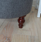 Circular round footstool upholstered in Warwick Rouen Charcoal Fabric With Turned Mahogany Hardwood  Legs