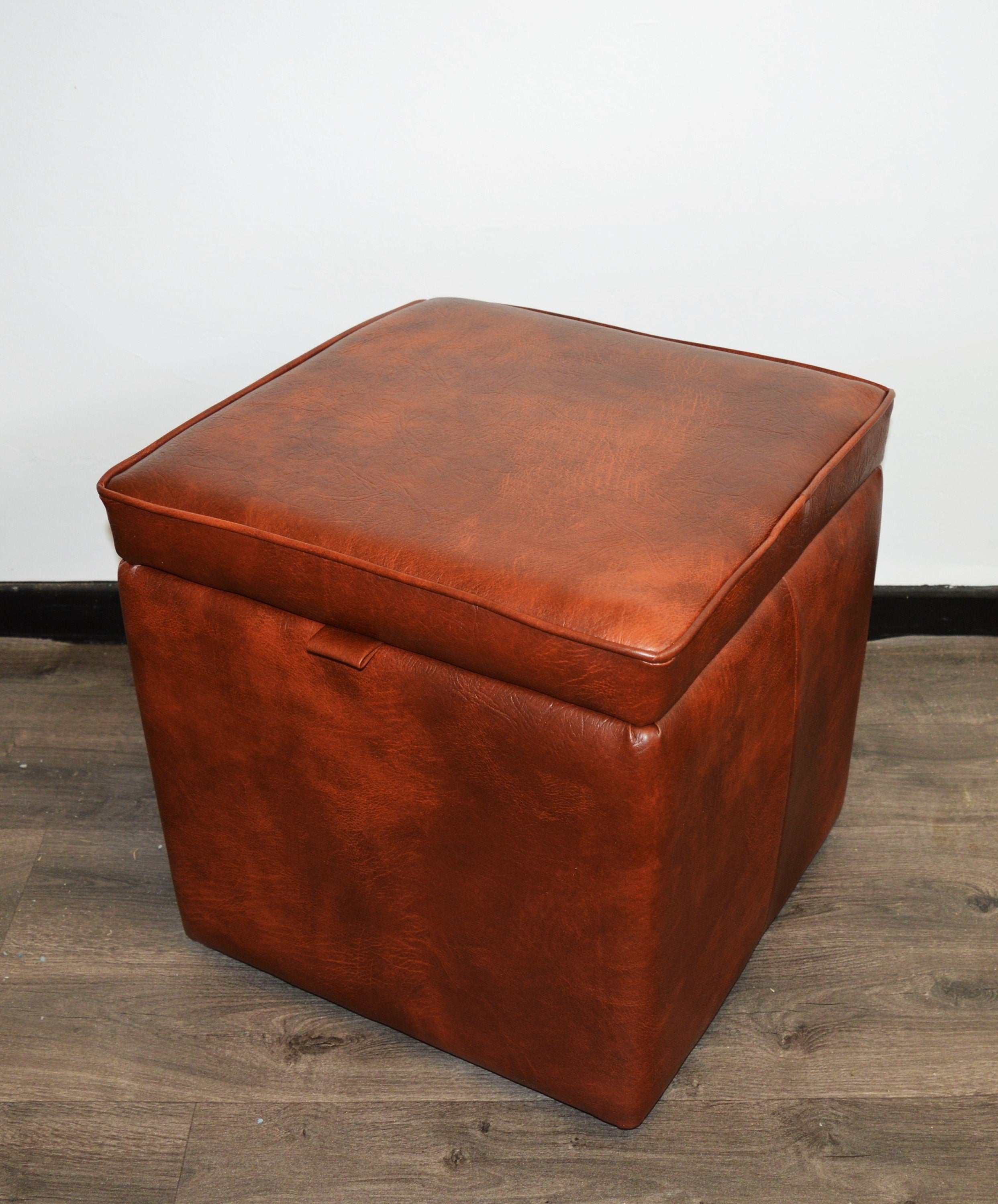 A Stylish  Cube Design footstool With Storage Ottoman footrest upholstered in a Premium Chestnut Faux Leather