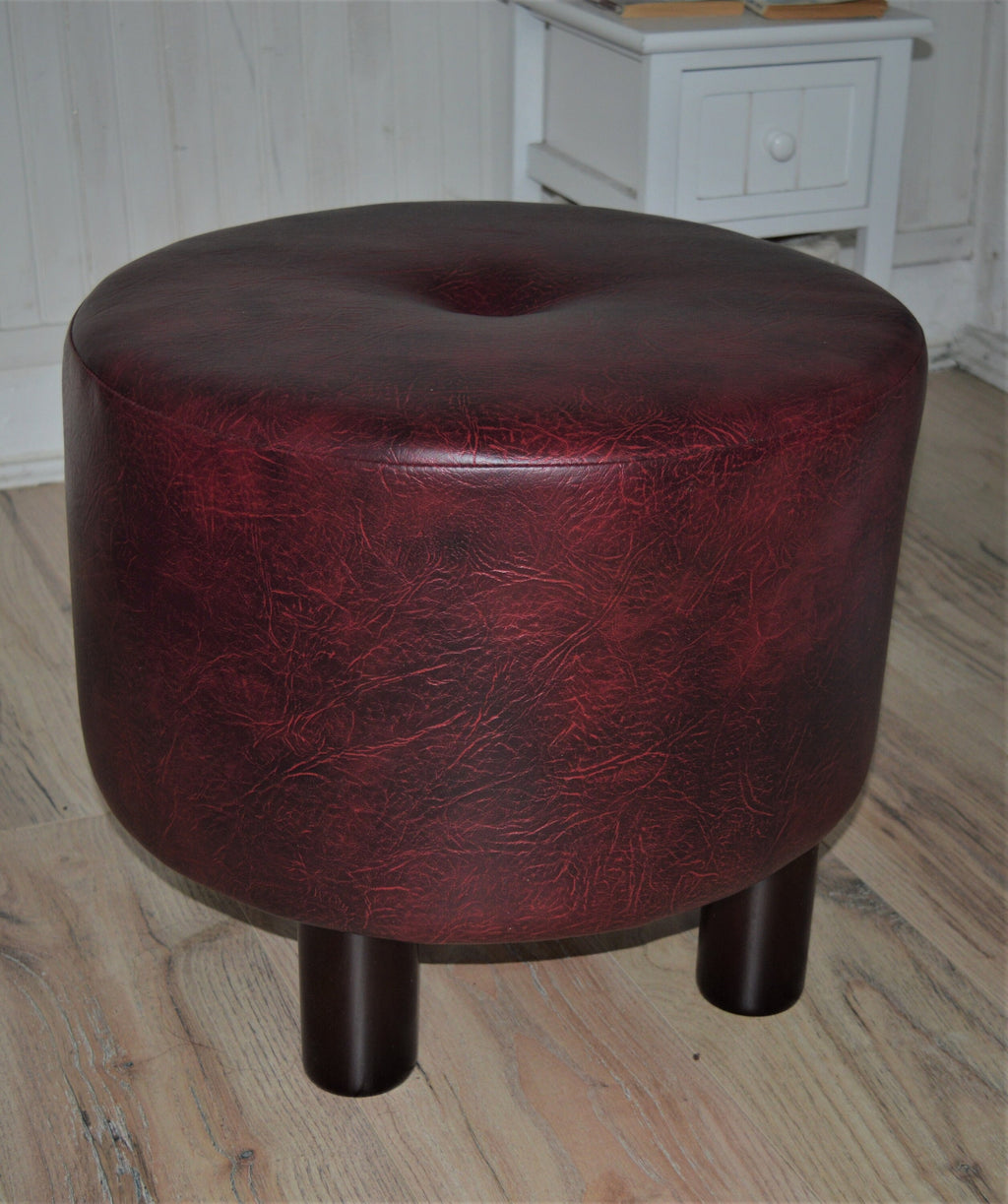 Circular round footstool upholstered in a premium wine faux leather with 4 cylinder Hard Wood Legs