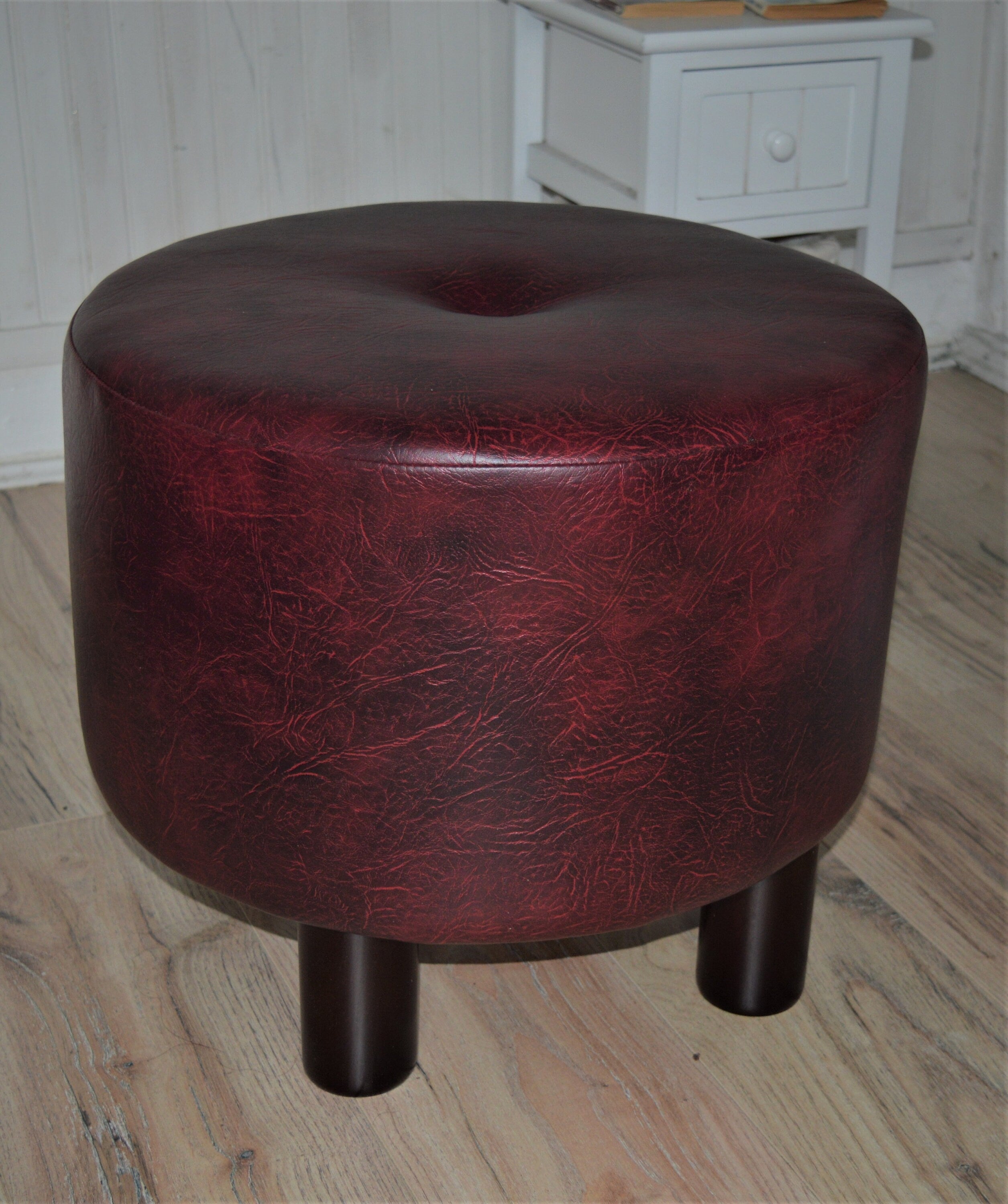 Circular round footstool upholstered in a premium wine faux leather with 4 cylinder Hard Wood Legs