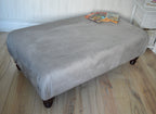 A Flat Top Footstool In Luxury Silver Velvet Fabric With Turned Mahogany Wood Legs