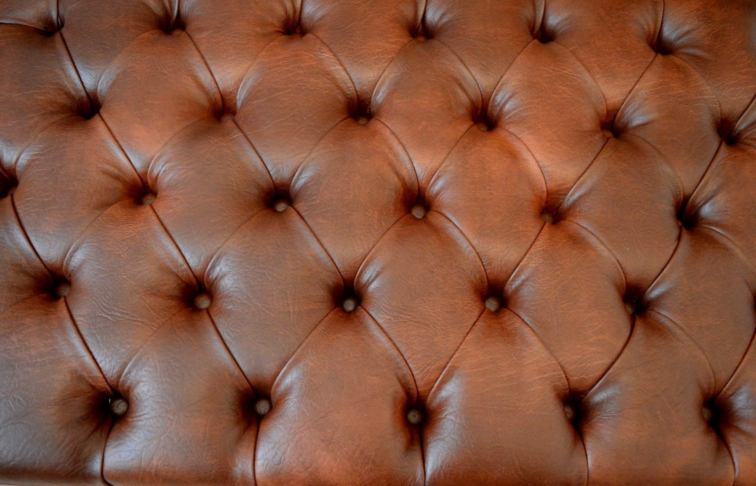 A Stylish UK Made Deep Buttoned Chesterfield Footstool in Premium Chestnut Faux Leather With Turned Hardwood Legs