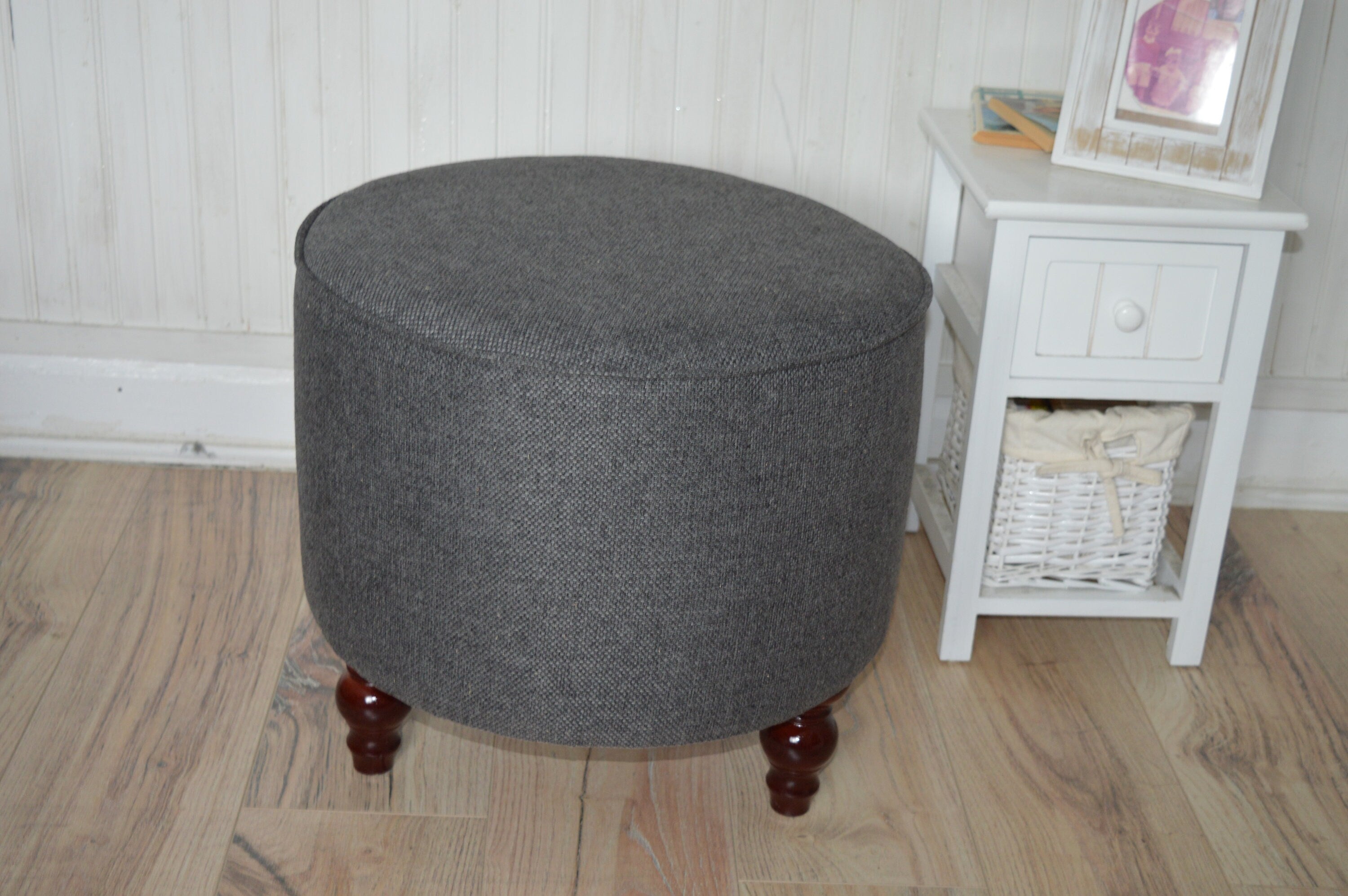 Circular round footstool upholstered in Warwick Rouen Charcoal Fabric With Turned Mahogany Hardwood  Legs