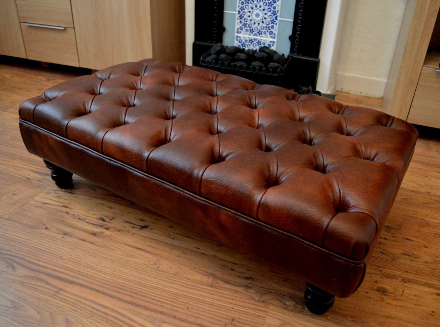 A Stylish UK Made Deep Buttoned Chesterfield Footstool in Premium Chestnut Faux Leather With Turned Hardwood Legs