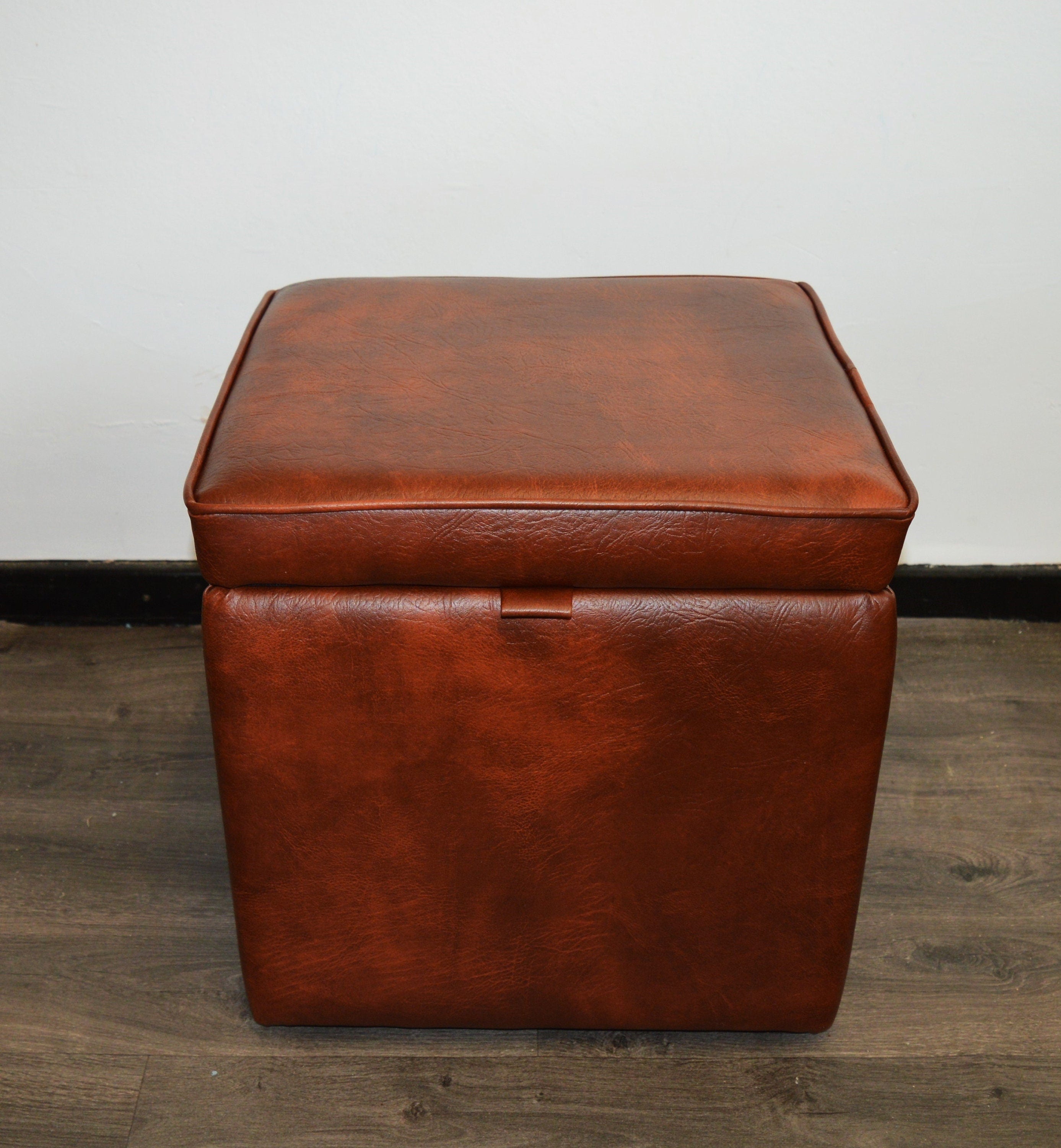 A Stylish  Cube Design footstool With Storage Ottoman footrest upholstered in a Premium Chestnut Faux Leather