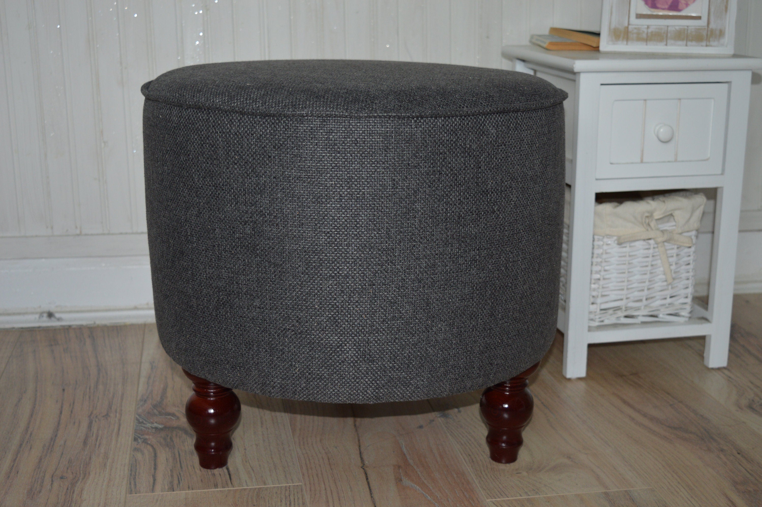 Circular round footstool upholstered in Warwick Rouen Charcoal Fabric With Turned Mahogany Hardwood  Legs