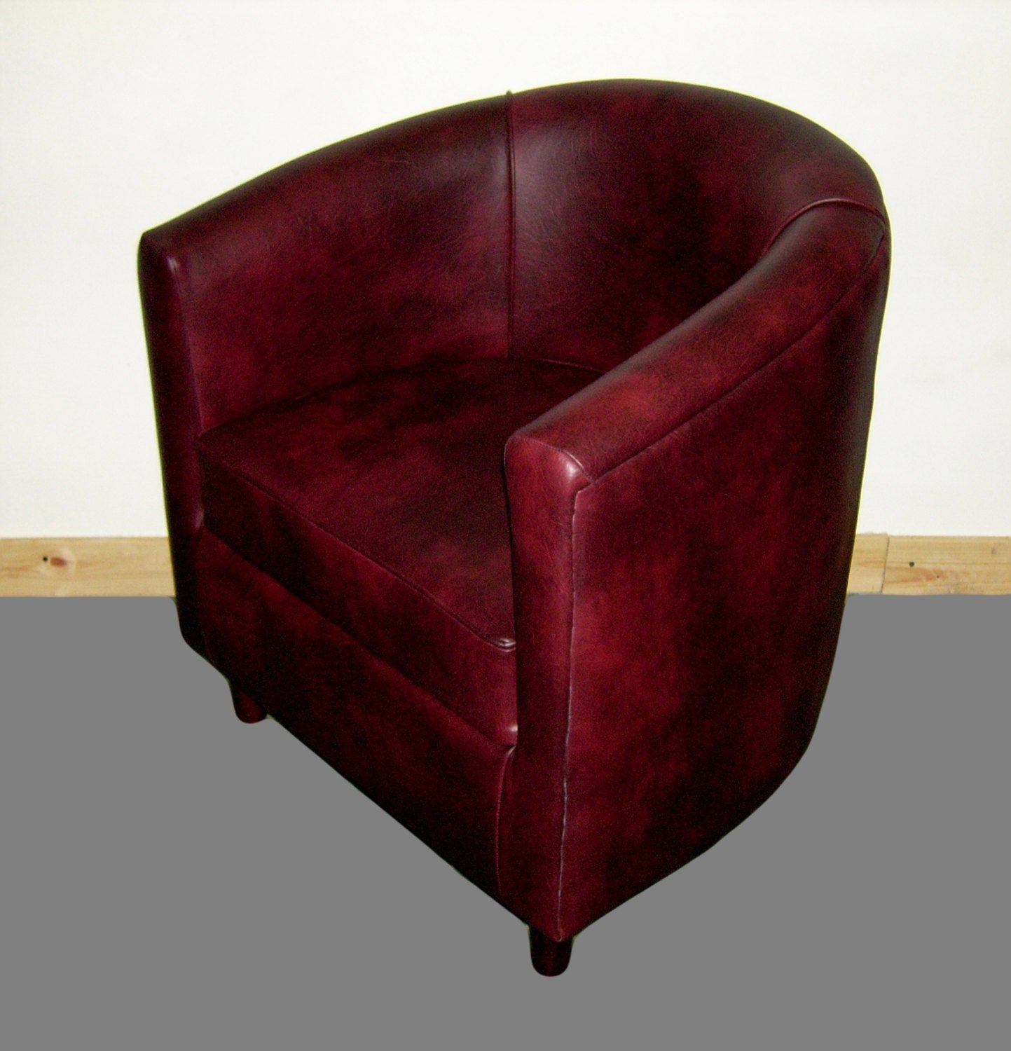 Tub Chair Upholstered In A Wine Faux Leather With Mahogany Wood Legs
