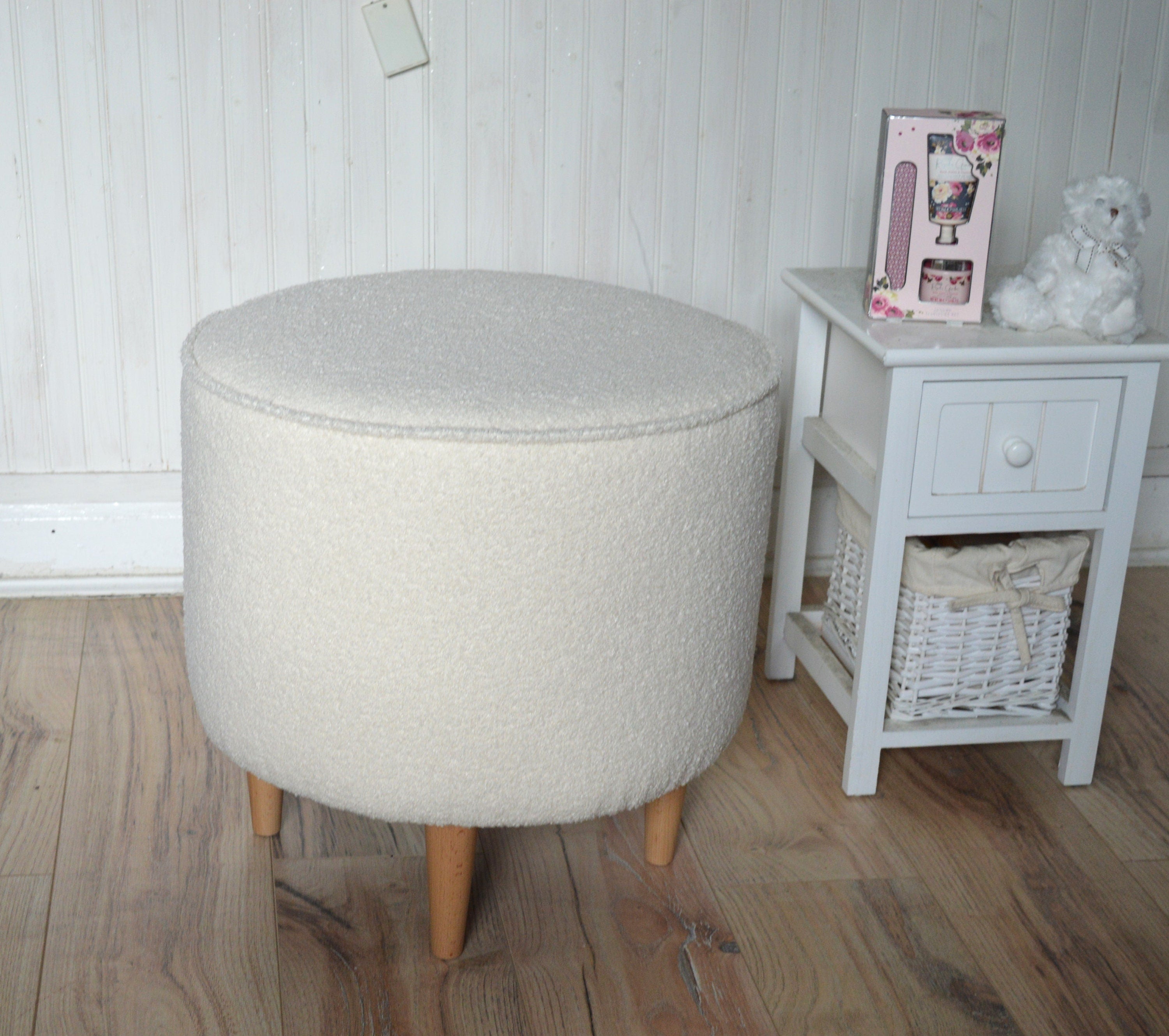 Circular round footstool upholstered in Ivory Boucle Fabric With Natural Hardwood  Legs