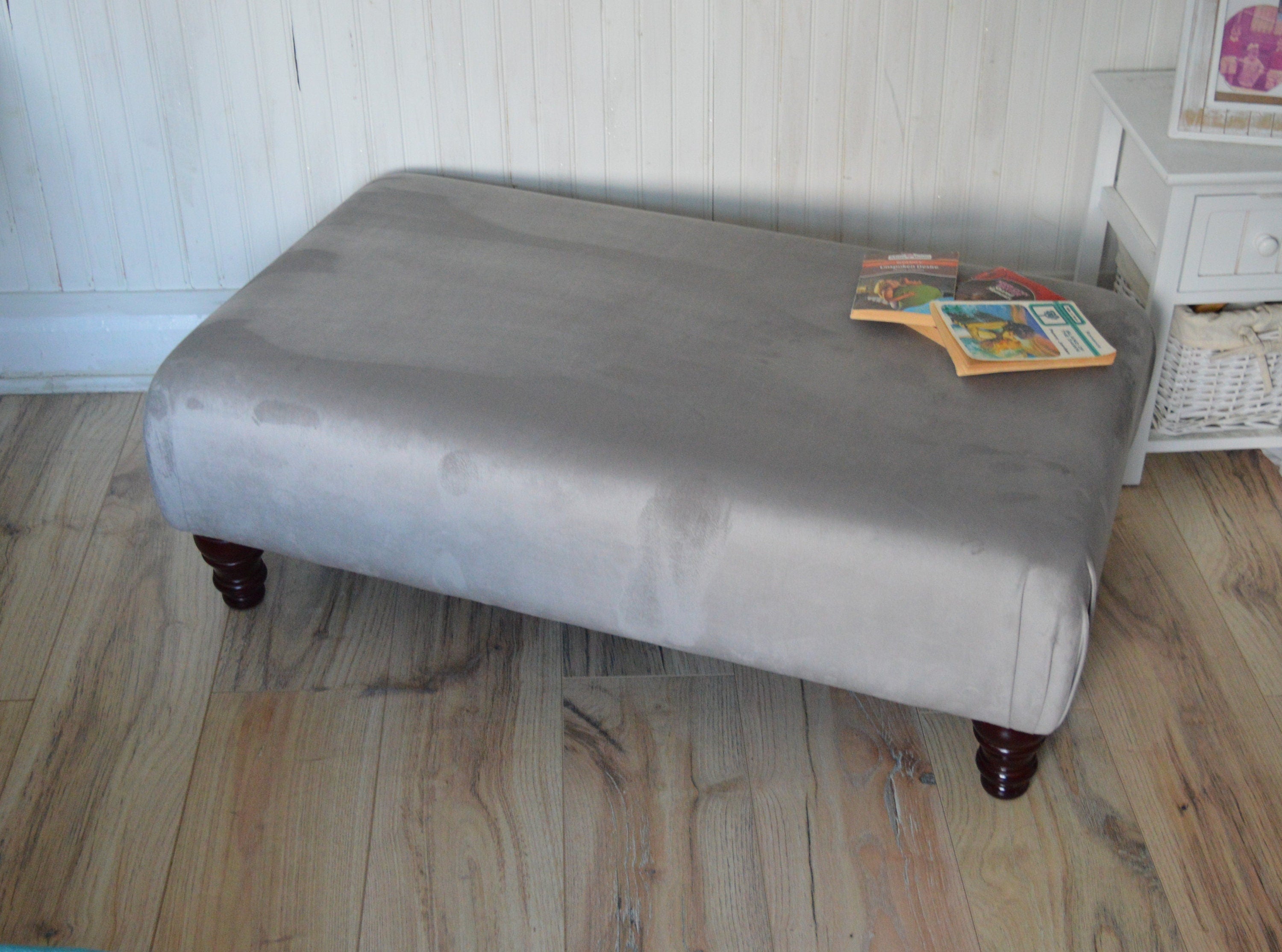 A Flat Top Footstool In Luxury Silver Velvet Fabric With Turned Mahogany Wood Legs