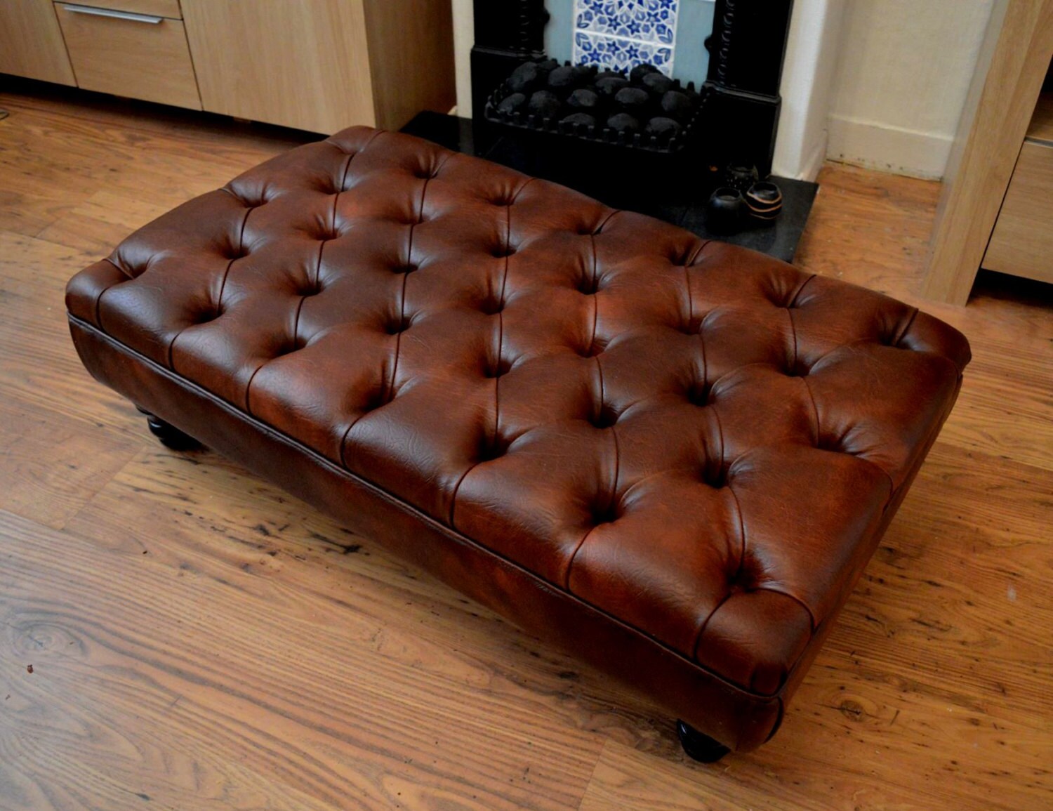 A Stylish UK Made Deep Buttoned Chesterfield Footstool in Premium Chestnut Faux Leather With Turned Hardwood Legs