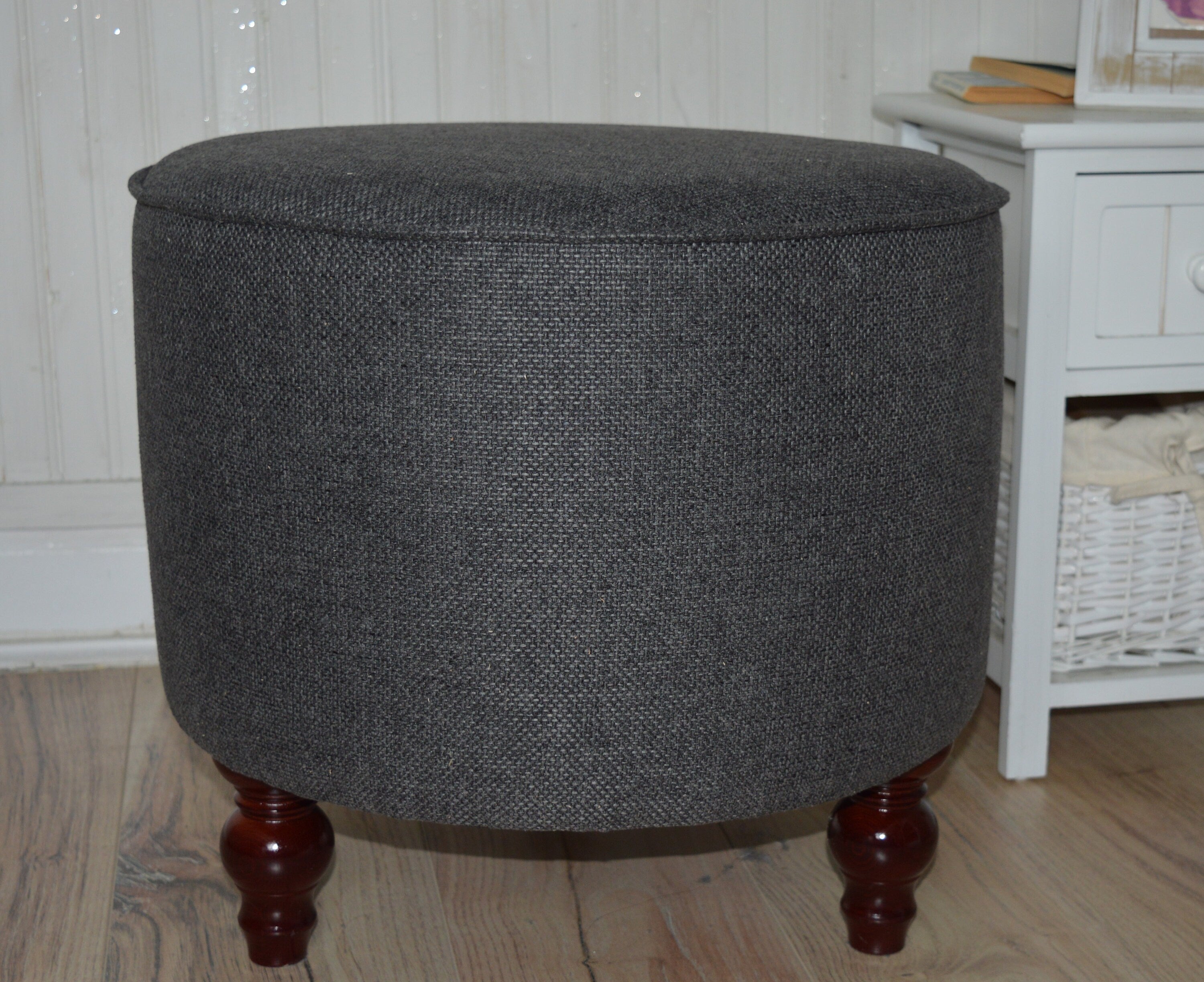 Circular round footstool upholstered in Warwick Rouen Charcoal Fabric With Turned Mahogany Hardwood  Legs